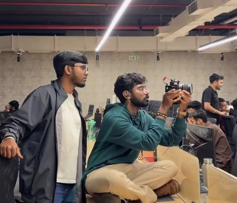 Two teammates framing a shot in the office