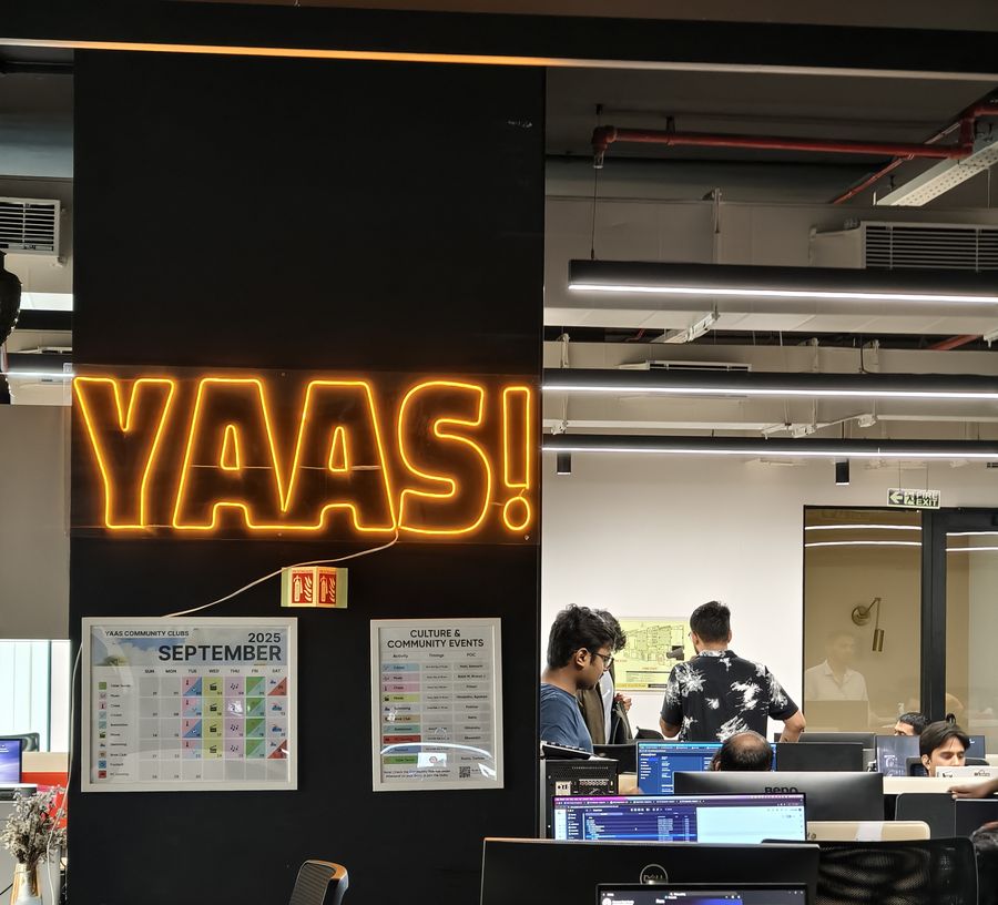 The YAAS neon sign above the office desks